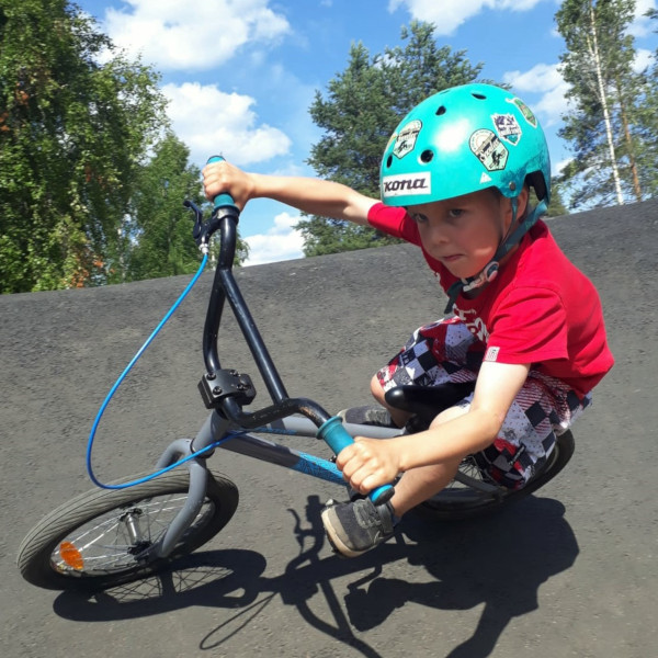 Pieni poika ajaa pyörällä pump track -radalla.